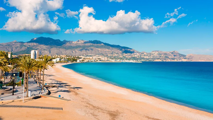 La playa del Albir y el paseo de palmeras, con la montaña al fondo